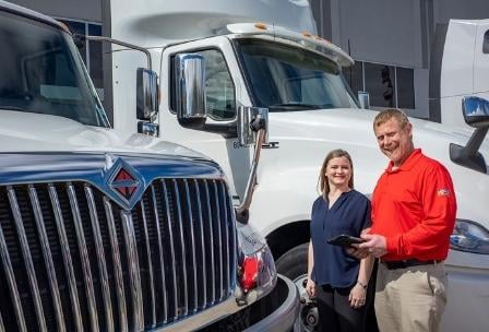 Rush Truck Leasing employee standing with customers next to truck