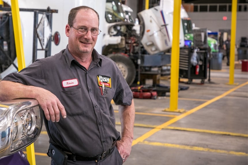 Technician leaning against truck headlight